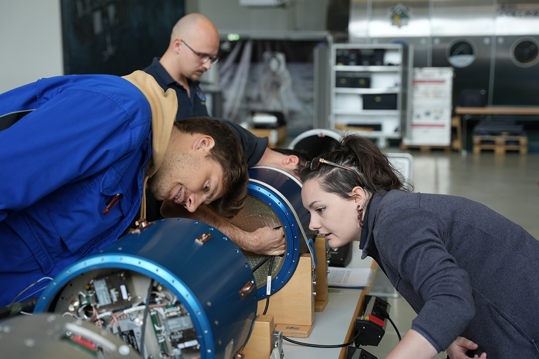 Armelle working on a rocket payload together with a student.