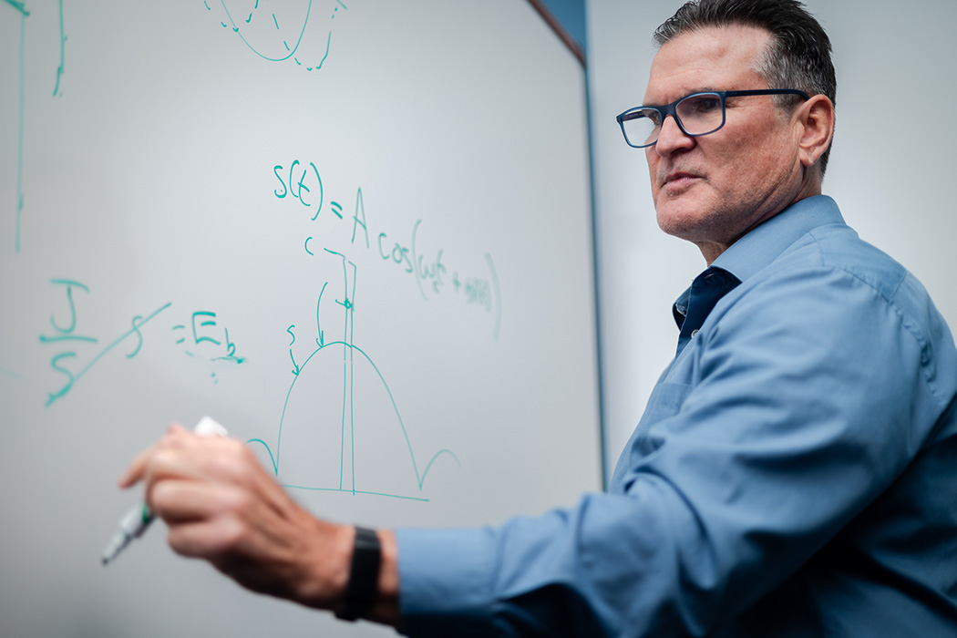 John Taylor writing on a board