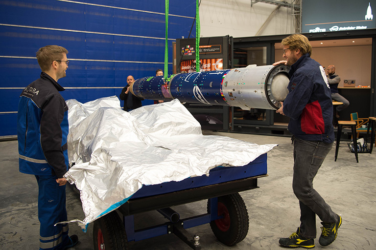 Engineers lifting a rocket module.