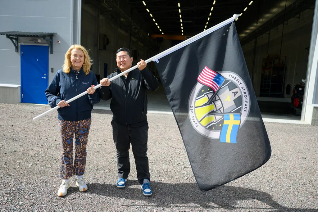 Charlotta Sund and Jason Kim carries a project flag