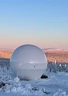 A radom in winter with mountain in the background