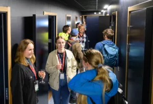Many persons standing inside a room with black walls